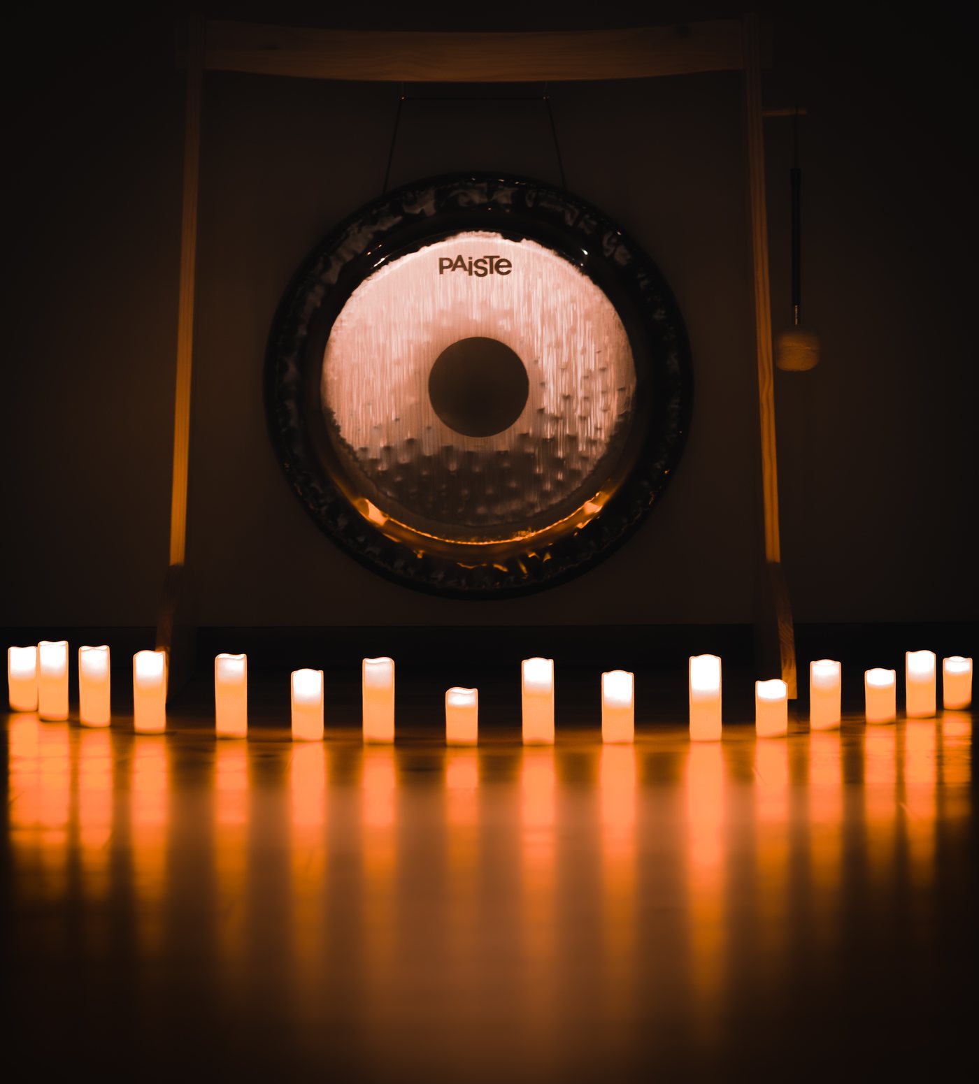 A gong lit by a row of candles in the studio